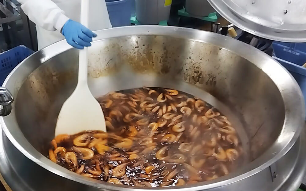 お弁当の調理風景　有頭えび蒸気釜で丁寧に煮上げています